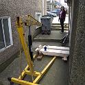 The hoist in position.    That's my sweetie, absolutely invaluable to the process, wearing pink and hoping to keep her hands clean.  Boy, is she in for a shock.  Note the stairs in the bottom left.  We have to go around the corner to the right.