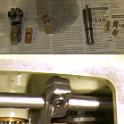 The top pic shows the broken sliders that started this whole project, and the replacements that I fabbed up.  I was willing to just pay the price for new ones, but no one had them in stock, so a length of 660 bronze rod was milled to size and drilled as close to center as possible.  The holes are amazingly large relative to the width of the slider; small wonder they failed.  The bottom pic shows an attempt to use a broken slider by drilling a new hole below the broken one.  It didn't really work, though; the whole length of the slider is needed.