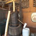 The raw licquor drips out of the bamboo pipe into the barrel, which is heated by a fire below.  Somehow, it makes its way into the large plastic keg on the right via the pop bottle.